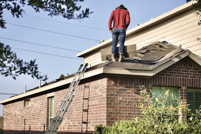 Professional roofer working on a residential roof in Ames